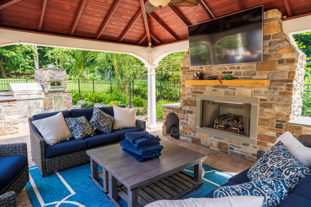 Outdoor living space with couches surrounding fireplace